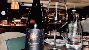 Garrafa de vinho e taça em mesa de restaurante