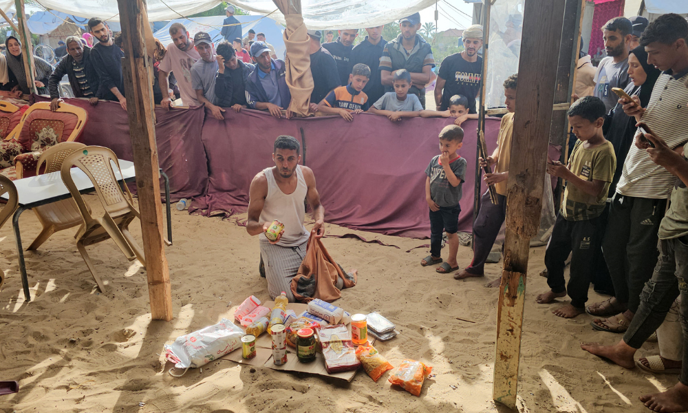 Palestinos deslocados recebem pacotes de alimentos de uma fundação apoiada pelos EUA que se compromete a distribuir ajuda humanitária no oeste de Rafah, no sul da Faixa de Gaza, em 27 de maio de 2025. Milhares de palestinos correram para um novo centro de distribuição de ajuda administrado por um grupo apoiado pelos EUA no sul de Gaza em 27 de maio, relataram jornalistas da AFP, o que provocou cenas caóticas enquanto Israel implementava um novo sistema de distribuição. O incidente em Rafah ocorreu dias após o alívio parcial do bloqueio total de ajuda ao território imposto por Israel em 2 de março, o que levou a uma grave escassez de alimentos e medicamentos. (Foto da AFP)